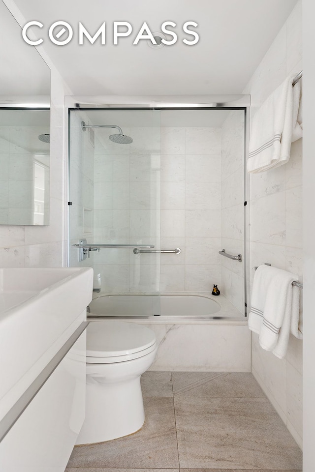 166 E 63rd St Unit 11Bc, New York City, NY 10065 - full bath featuring toilet, combined bath / shower with glass door, vanity, and tile patterned flooring