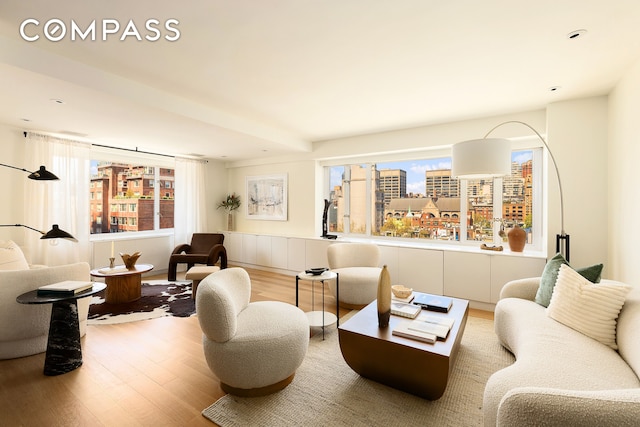 166 E 63rd St Unit 11Bc, New York City, NY 10065 - living area featuring wood finished floors, a city view, and a wainscoted wall