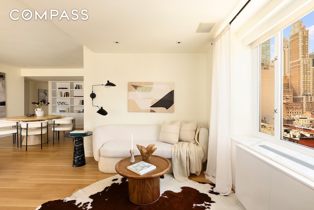 166 E 63rd St Unit 11Bc, New York City, NY 10065 - living area with wood finished floors and a city view