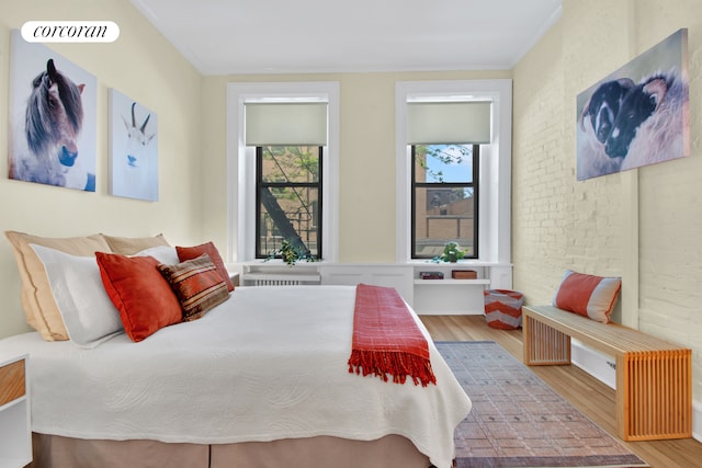 330 W 17th St Unit 2E, New York City, NY 10011 - bedroom with wood finished floors, ornamental molding, and brick wall