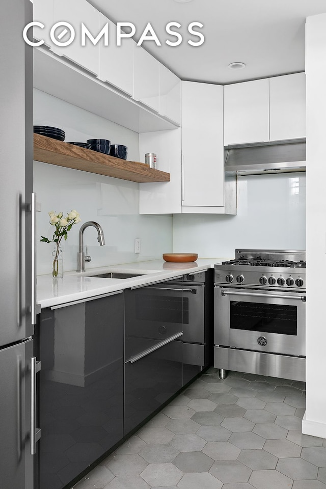 49 E 12th St Unit 2C, New York City, NY 10003 - kitchen with appliances with stainless steel finishes, range hood, a sink, and modern cabinets