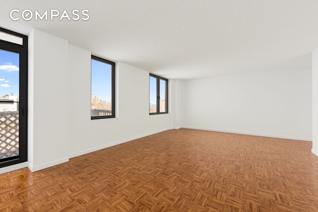 unfurnished room with plenty of natural light and baseboards