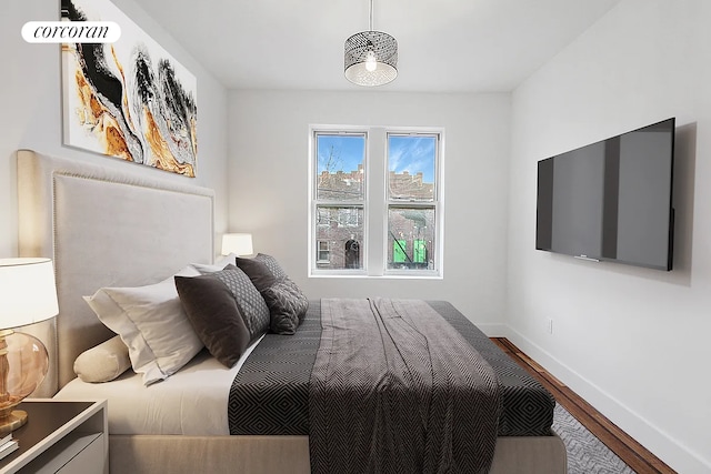 bedroom with baseboards and wood finished floors