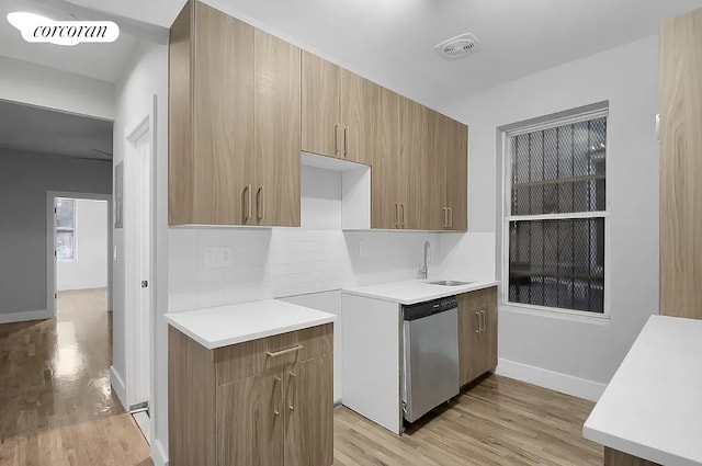 kitchen with dishwasher, light countertops, light wood-style flooring, tasteful backsplash, and visible vents