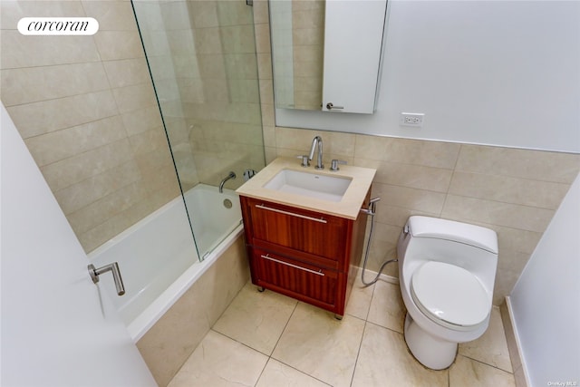 full bath with tiled shower / bath combo, toilet, tile walls, and vanity