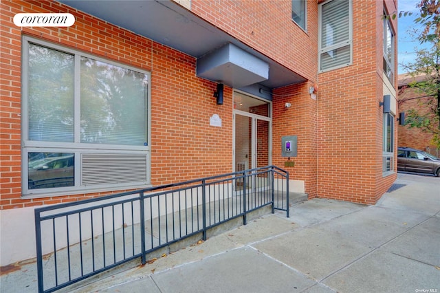 entrance to property featuring brick siding