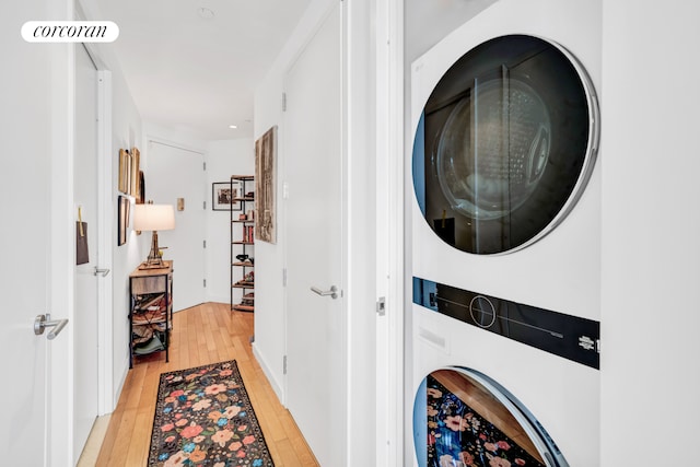 laundry area featuring laundry area, stacked washer and clothes dryer, visible vents, recessed lighting, and light wood finished floors