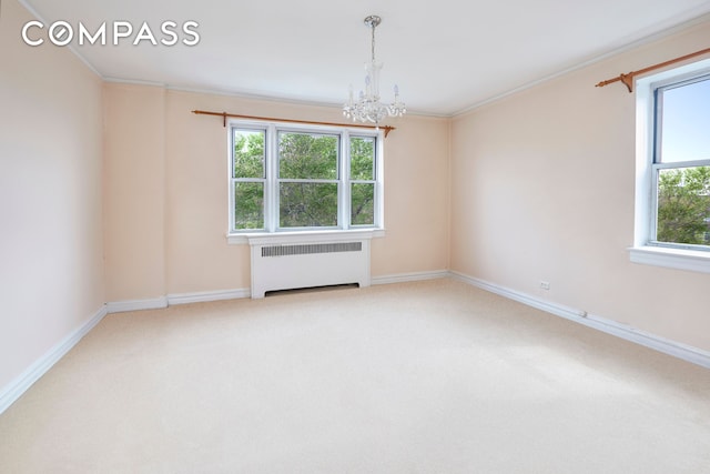 empty room featuring baseboards, a chandelier, radiator heating unit, and carpet