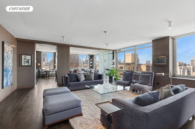 living room with plenty of natural light, a city view, wood finished floors, and visible vents