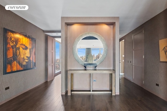 corridor featuring visible vents, baseboards, and hardwood / wood-style flooring