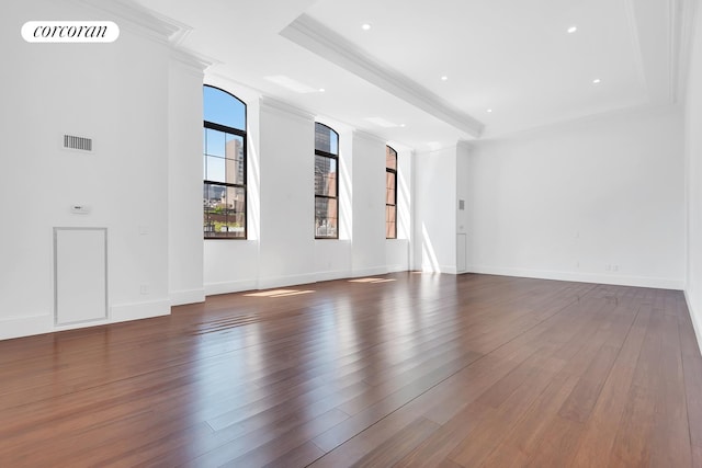 unfurnished living room featuring visible vents, ornamental molding, dark wood-style flooring, baseboards, and a raised ceiling