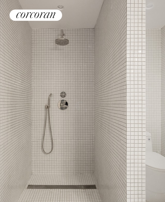full bath featuring toilet and tiled shower