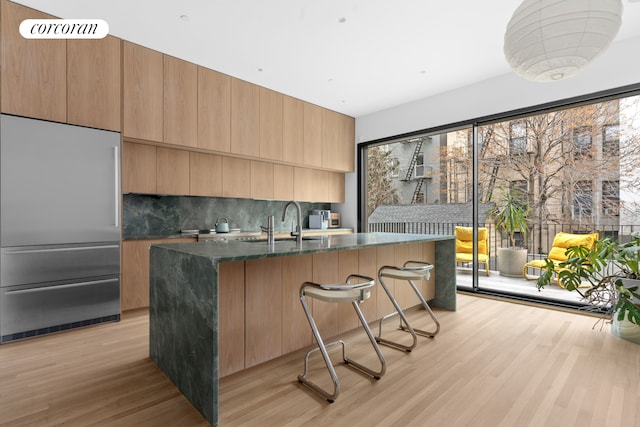 690 Humboldt St, New York City, NY 11222 - kitchen with built in refrigerator, a sink, decorative backsplash, modern cabinets, and light wood-style floors