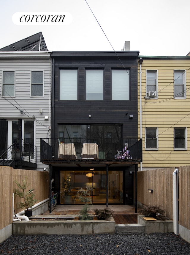 rear view of property featuring a fenced backyard and a patio area