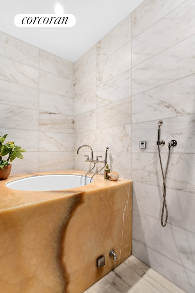 bathroom with a tub, tile walls, and a marble finish shower