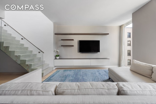 living area featuring wood finished floors and stairway