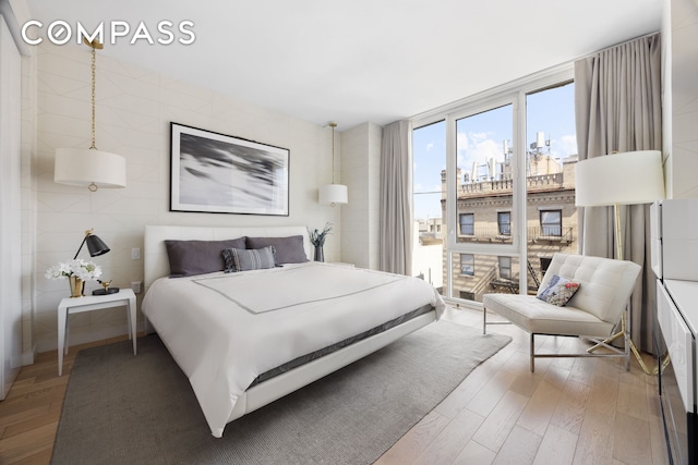 540 W 49th St Unit Ph1N, New York City, NY 10019 - bedroom with access to exterior, wood finished floors, and a wall of windows