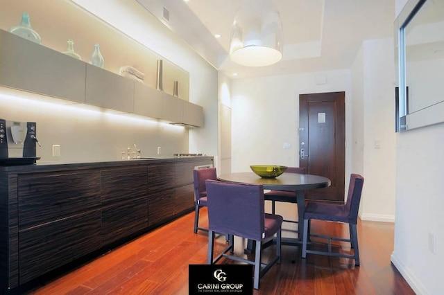 55 Wall St Unit 632, New York City, NY 10005 - dining room featuring wet bar, wood finished floors, and a raised ceiling