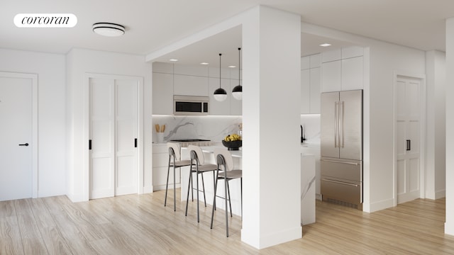 interior space featuring visible vents, decorative backsplash, high end fridge, white microwave, and light wood-type flooring