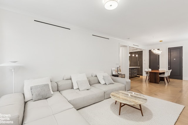 living room with crown molding, a chandelier, and baseboards