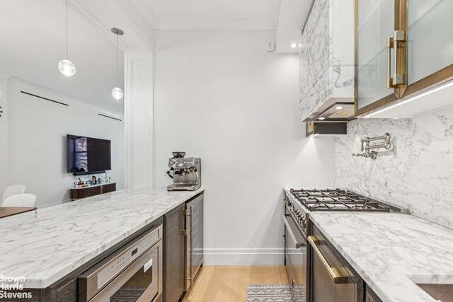 kitchen with appliances with stainless steel finishes, backsplash, light stone counters, a peninsula, and baseboards