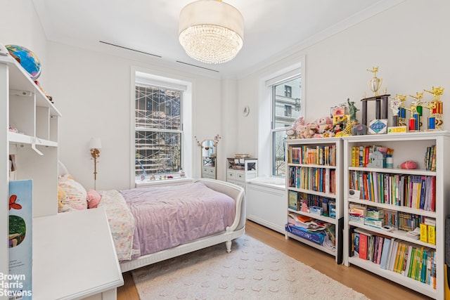 bedroom featuring light wood-style flooring and crown molding