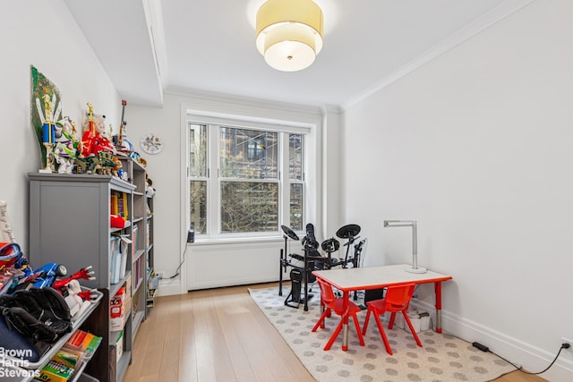 dining area featuring hardwood / wood-style floors, baseboards, and crown molding