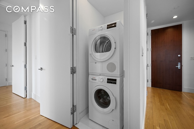 washroom featuring recessed lighting, laundry area, stacked washer and dryer, and light wood-style flooring