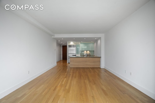unfurnished living room featuring light wood-style floors and baseboards