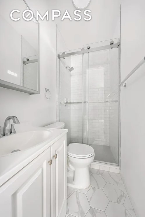 134 W 80th St Unit 2R, New York City, NY 10024 - bathroom featuring toilet, a stall shower, vanity, and marble finish flooring