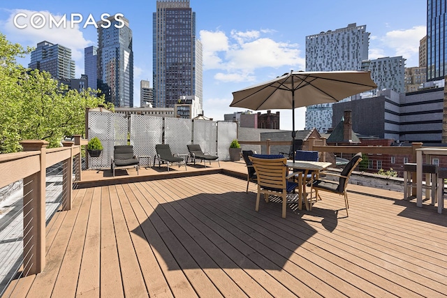 deck featuring a view of city and outdoor dining area