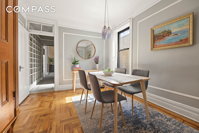 dining space with crown molding and baseboards