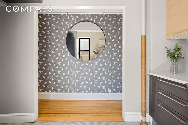 room details with baseboards, wallpapered walls, and wood finished floors