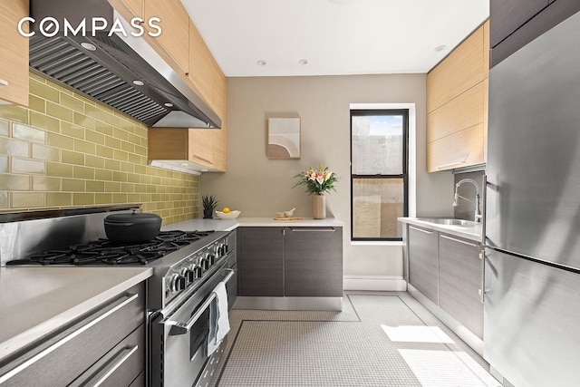 kitchen featuring light countertops, appliances with stainless steel finishes, ventilation hood, and backsplash