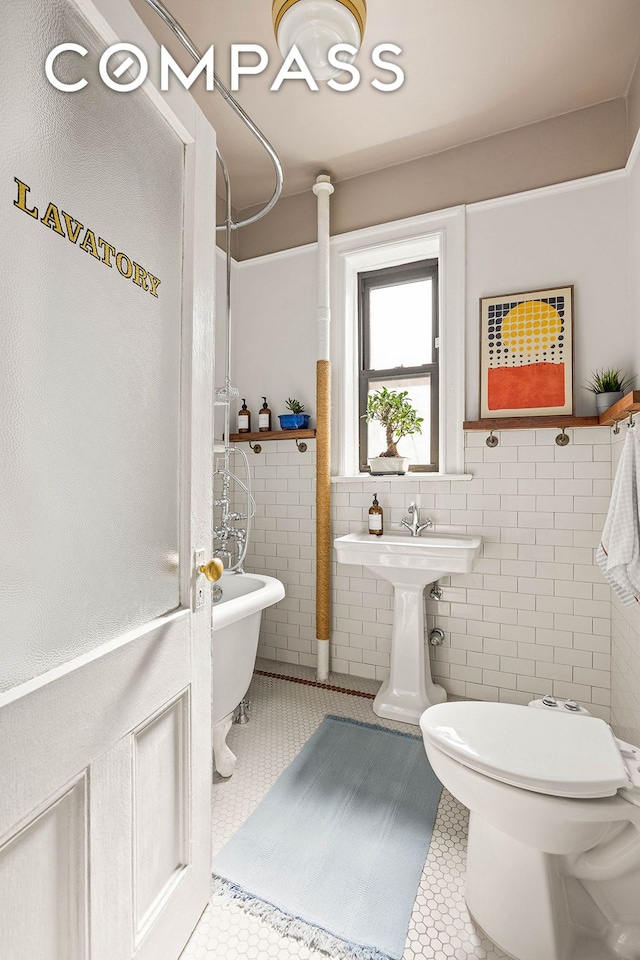 bathroom featuring tile patterned flooring, toilet, tile walls, walk in shower, and a soaking tub