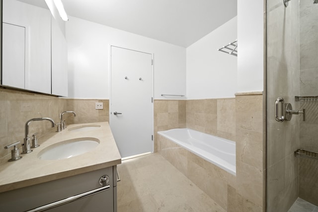 121 W 19th St Unit 9E, New York City, NY 10011 - full bath featuring double vanity, a garden tub, a stall shower, tile walls, and wainscoting