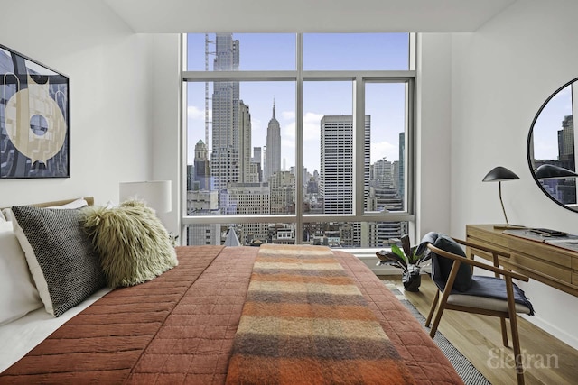 18 W 48th St Phd, Phd, New York City, NY 10036 - bedroom featuring a wall of windows, a view of city, multiple windows, and wood finished floors