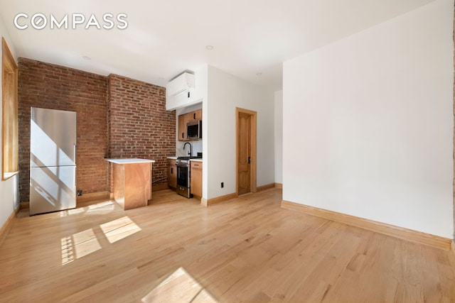 632 W 158th St, New York City, NY 10032 - unfurnished living room featuring baseboards, light wood-style flooring, and a wall unit AC