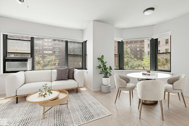 dining space featuring baseboards, wood finished floors, and cooling unit
