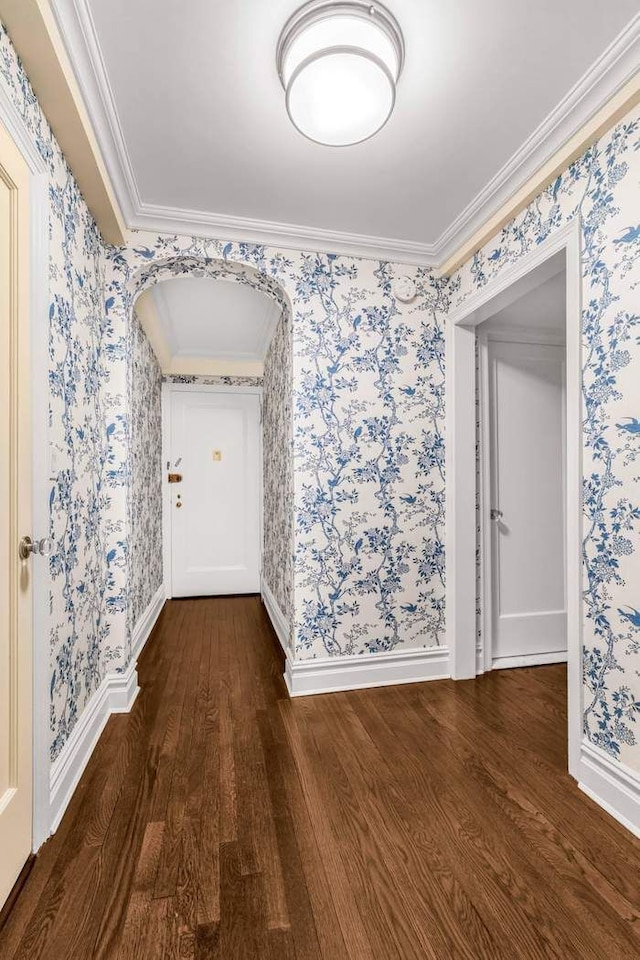 empty room with ornamental molding, dark wood-style floors, and wallpapered walls