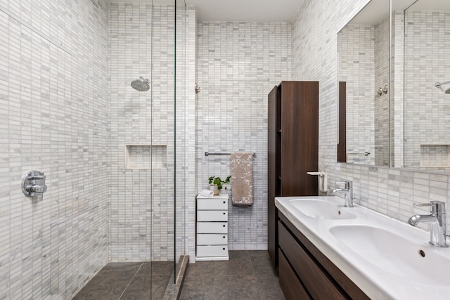 bathroom with tile walls, a sink, and a stall shower