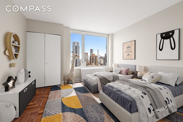 bedroom featuring a closet, a city view, and baseboards
