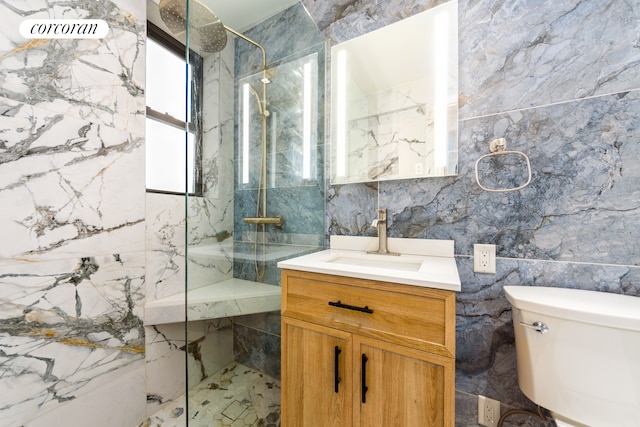 bathroom with tile walls, a marble finish shower, and vanity
