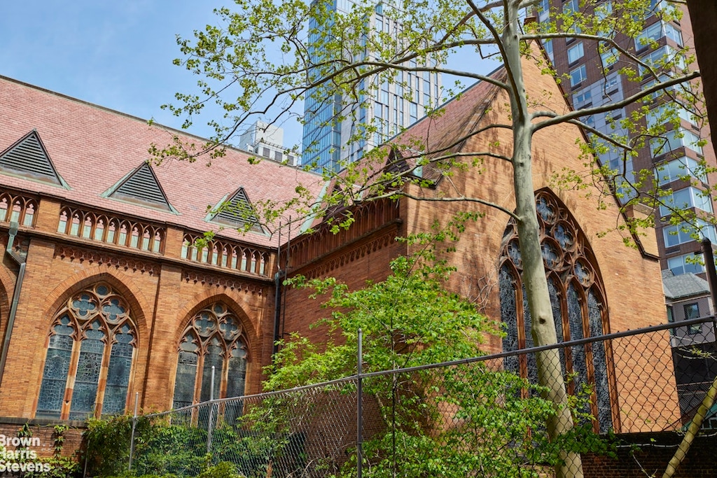 view of property exterior with brick siding and fence