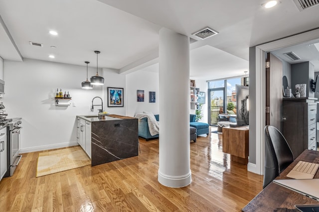 554 4th Ave Unit 3D, New York City, NY 11215 - kitchen featuring a sink, a peninsula, open floor plan, light wood-style flooring, and baseboards