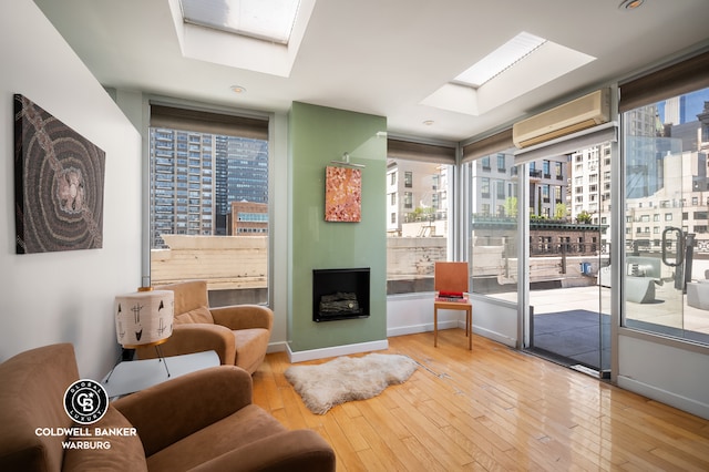 115 E 61st St Ph, Ph, New York City, NY 10065 - living area featuring a skylight, a wall mounted air conditioner, and hardwood / wood-style flooring