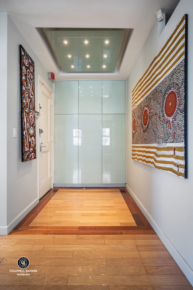 115 E 61st St Ph, Ph, New York City, NY 10065 - corridor featuring wood-type flooring, a raised ceiling, recessed lighting, and baseboards