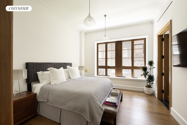 bedroom featuring baseboards, ornamental molding, and hardwood / wood-style floors