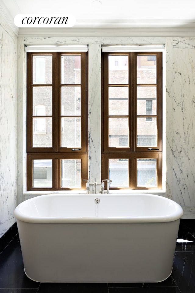 bathroom featuring a soaking tub and stone wall