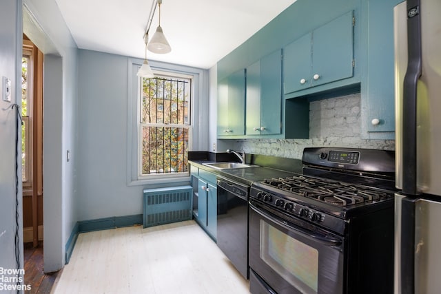 kitchen featuring a sink, radiator, decorative backsplash, black appliances, and blue cabinets